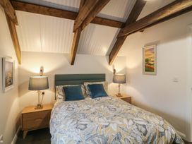A bedroom with a bed, bedside tables, and lamps at The Loft in Glenmore, County Kilkenny