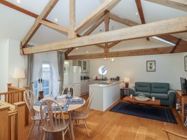 A living room with a dining area and kitchen at Hilldown Granary near Bow