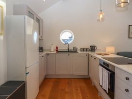 A kitchen with sink and refrigerator at Hilldown Granary near Bow