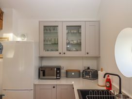 A kitchen with appliances and glassware at Hilldown Granary near Bow