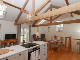 A kitchen with a stove and dining area at Hilldown Granary near Bow