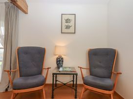 A sitting room with two rocking chairs and a lamp at Hilldown Granary near Bow