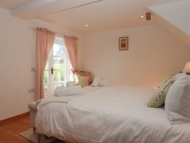 A bedroom with a bed and window at Hilldown Granary near Bow