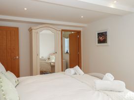 A bedroom with a bed and wardrobe at Hilldown Granary near Bow