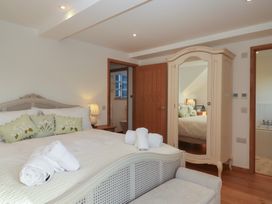 A bedroom with a bed and wardrobe at Hilldown Granary near Bow
