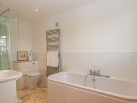 A bathroom with a bathtub, shower, toilet, and sink at Hilldown Granary near Bow