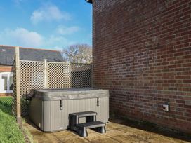 An outdoor area with a hot tub and step stool at Hilldown Granary near Bow