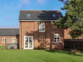 A brick building with windows and a hot tub near Hilldown Granary near Bow