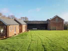 An outdoor area with brick houses and a grassy field at Hilldown Granary near Bow