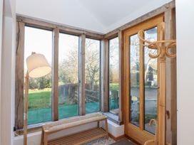 A conservatory with a lamp and a bench at Hilldown Cott near Bow