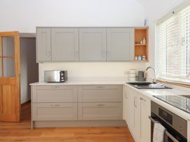 A kitchen with cabinets and a countertop at Hilldown Cott near Bow