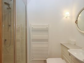 A bathroom with a shower, sink, and towel rail at Hilldown Cott near Bow