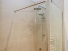 A shower with glass enclosure and towel radiator at Hilldown Cott near Bow