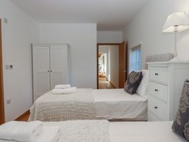 A bedroom with two single beds and a wardrobe at Hilldown Cott near Bow