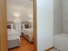 A bedroom with two beds and a bathtub at Hilldown Cott near Bow