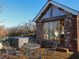 An outdoor patio with a table and chairs at Hilldown Cott near Bow