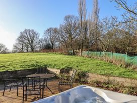 A garden with chairs and a table near a hot tub at Hilldown Cott near Bow