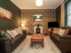 A living room with a fireplace and television at Daisy cottage in Pickering