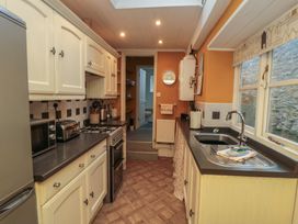 A kitchen with appliances and cabinets at Daisy cottage in Pickering
