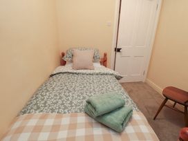 A bedroom with a single bed and towels at Daisy cottage in Pickering