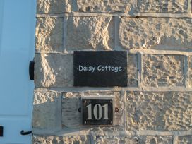 A house sign and number 101 on a stone wall at Daisy cottage in Pickering