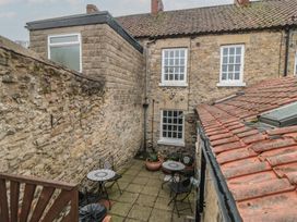 An outdoor area with stone walls and patio furniture at Daisy cottage in Pickering
