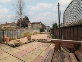 A garden with paving stones and plant pots at Daisy cottage in Pickering
