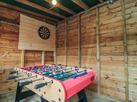 A foosball table and dartboard in a recreation room at Daisy cottage Pickering