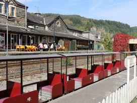 An outdoor area with train cars and a coffee shop at Noddfa in Penmachno