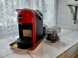 A coffee machine and a jar with coffee pods on a kitchen counter at Noddfa Penmachno