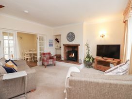 A living room with a fireplace and television at The Hideaway in Penrhyn Bay