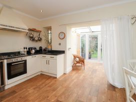 A kitchen with an oven and a doorway to a garden at The Hideaway in Penrhyn Bay