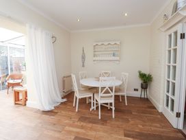 A dining room with a round table and chairs at The Hideaway in Penrhyn Bay