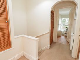 A hallway with a staircase and door leading to a room at The Hideaway in Penrhyn Bay