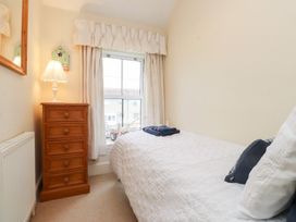 A bedroom with a bed and a dresser at The Hideaway in Penrhyn Bay