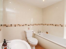 A bathroom with a bathtub, toilet, and sink at The Hideaway in Penrhyn Bay