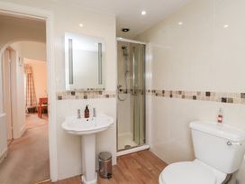 A bathroom with a sink, toilet, and shower at The Hideaway in Penrhyn Bay