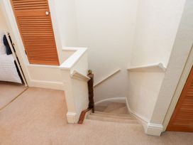 A staircase with a handrail and a door at The Hideaway in Penrhyn Bay