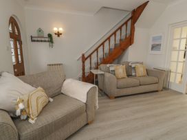 A living room with sofas and a staircase at The Hideaway in Penrhyn Bay