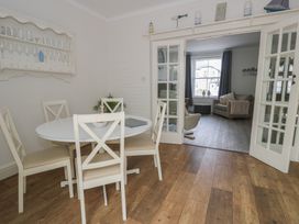 A dining room with a round table and chairs at The Hideaway in Penrhyn Bay