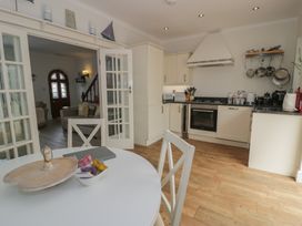 A kitchen with dining table and chairs at The Hideaway in Penrhyn Bay
