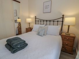 A bedroom with a bed and bedside tables at The Hideaway in Penrhyn Bay
