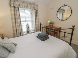 A bedroom with a bed and bedside table at The Hideaway in Penrhyn Bay