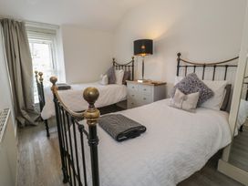 A bedroom with two beds and a nightstand at The Hideaway in Penrhyn Bay