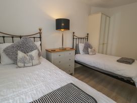 A bedroom with two single beds and a lamp at The Hideaway in Penrhyn Bay