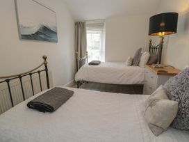 A bedroom with two beds and a nightstand at The Hideaway in Penrhyn Bay