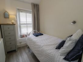 A bedroom with a bed and a dresser at The Hideaway in Penrhyn Bay