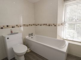 A bathroom with a bathtub, toilet, and sink at The Hideaway Penrhyn Bay