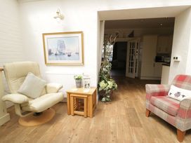 A conservatory with a chair and table at The Hideaway in Penrhyn Bay