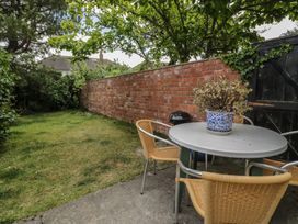 A garden with a table and chairs at The Hideaway in Penrhyn Bay